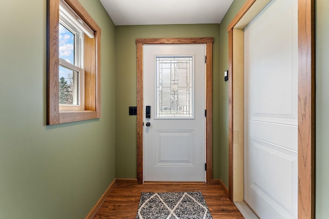 doorway with baseboards and wood finished floors