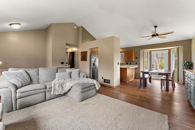 living area featuring dark wood-style flooring, ceiling fan, high vaulted ceiling, baseboards, and visible vents