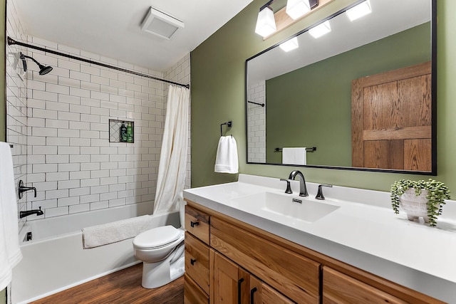 full bathroom with vanity, shower / bathtub combination with curtain, wood finished floors, and toilet