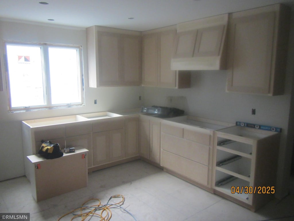 kitchen with light countertops, light brown cabinetry, and ventilation hood