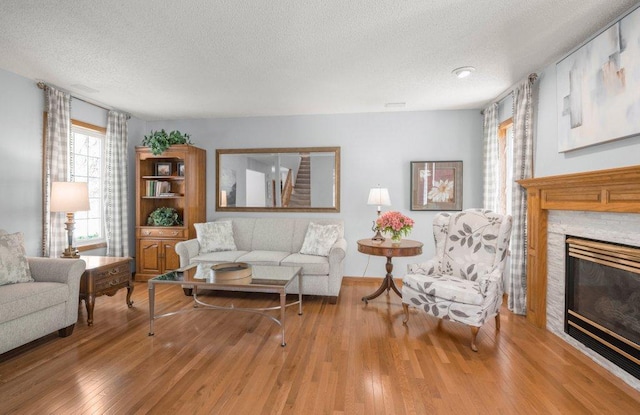 9967 Egret Blvd NW, Coon Rapids, MN 55433 - living room with a textured ceiling, wood finished floors, and a stone fireplace
