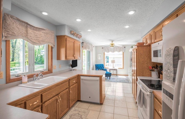 9967 Egret Blvd NW, Coon Rapids, MN 55433 - kitchen with white appliances, a sink, a textured ceiling, a peninsula, and light countertops