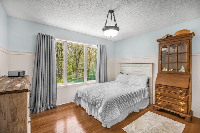 9967 Egret Blvd NW, Coon Rapids, MN 55433 - bedroom with a wainscoted wall, wood finished floors, and a textured ceiling