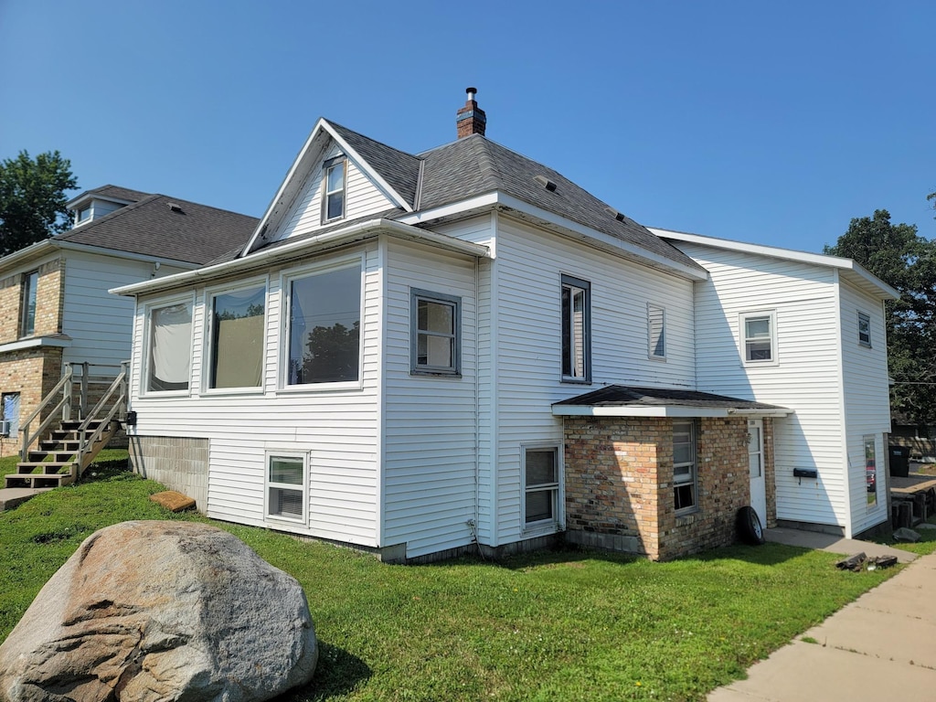 157 10th Ave N, Waite Park, MN 56387 - back of house featuring a chimney and a yard