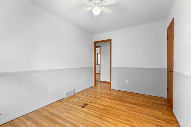 3618 1st St NW, Rochester, MN 55901 - spare room with wood finished floors, a wainscoted wall, and a ceiling fan