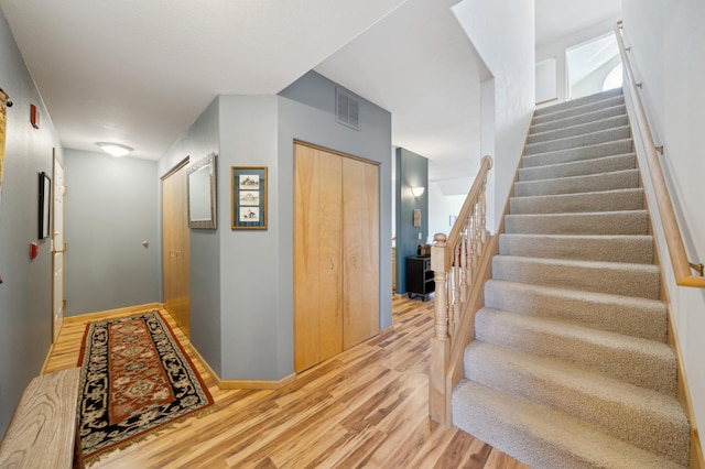 staircase featuring wood finished floors and baseboards