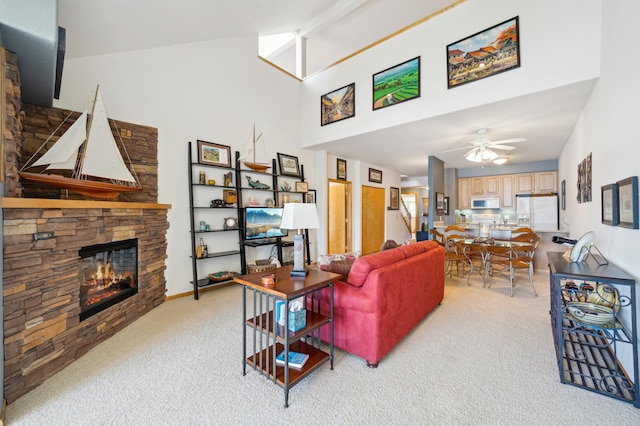 living room featuring light carpet, a fireplace, a ceiling fan, and high vaulted ceiling