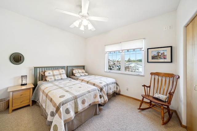 bedroom featuring light carpet, baseboards, and ceiling fan