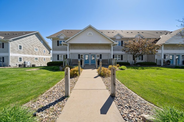 view of front of property featuring a front lawn and cooling unit
