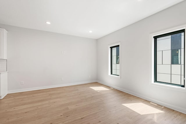 unfurnished room featuring recessed lighting, baseboards, visible vents, and light wood-style flooring
