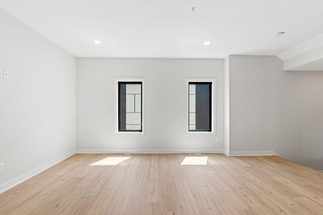 empty room with baseboards, recessed lighting, and light wood-style flooring