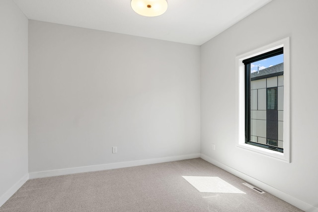 carpeted spare room with baseboards and visible vents