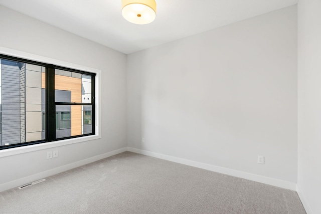 carpeted empty room with baseboards and visible vents