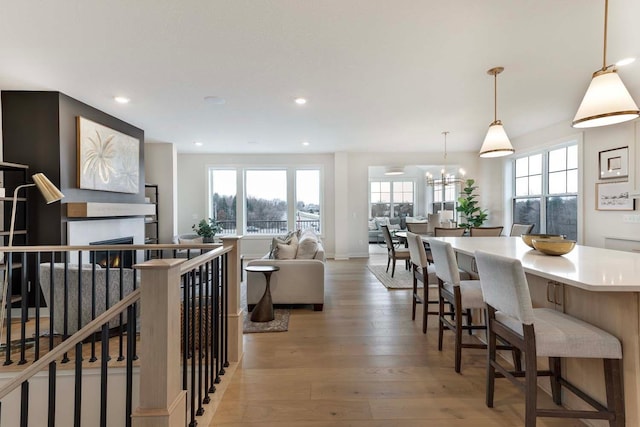 living room with a healthy amount of sunlight, recessed lighting, light wood finished floors, and a notable chandelier