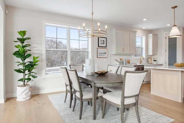 dining space featuring an inviting chandelier, baseboards, recessed lighting, and light wood-style flooring