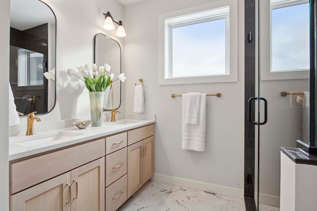 bathroom with double vanity, baseboards, a sink, and marble finish floor