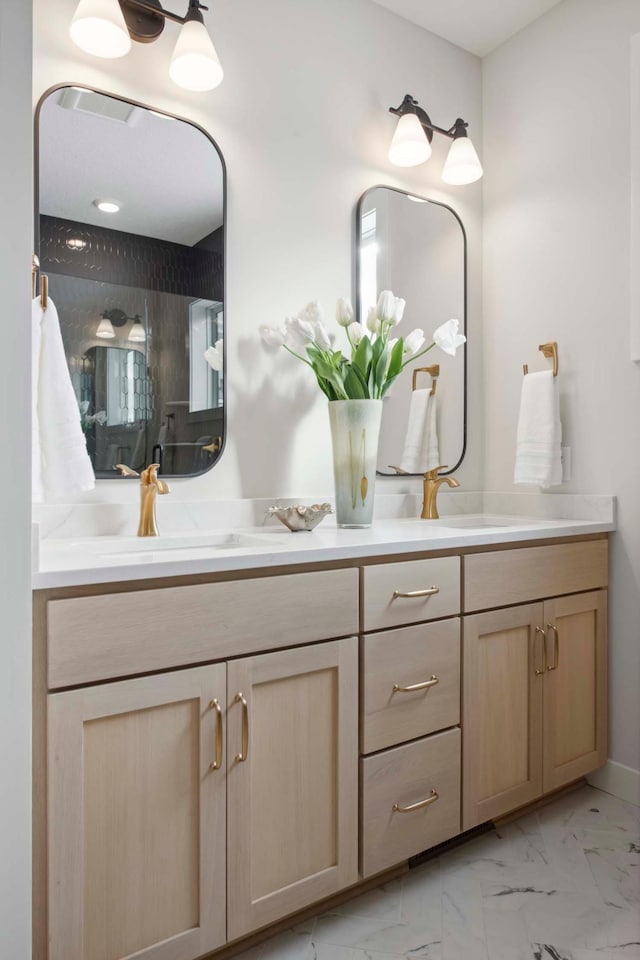 full bath featuring double vanity, a sink, and marble finish floor