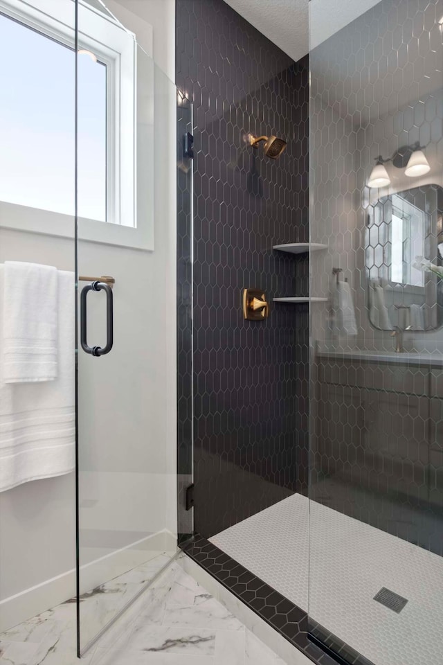 full bathroom with marble finish floor and a shower stall