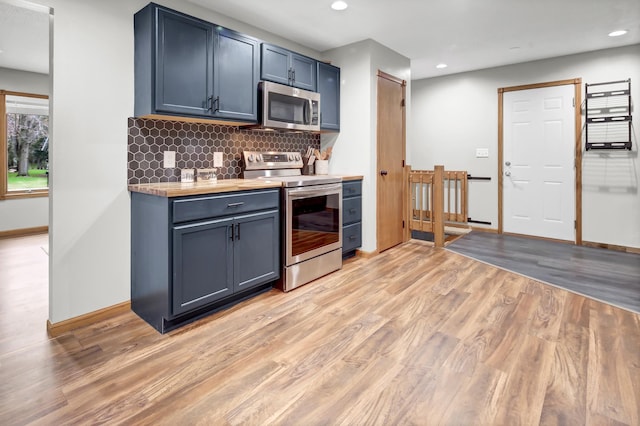 kitchen with backsplash, stainless steel appliances, recessed lighting, and light wood-type flooring