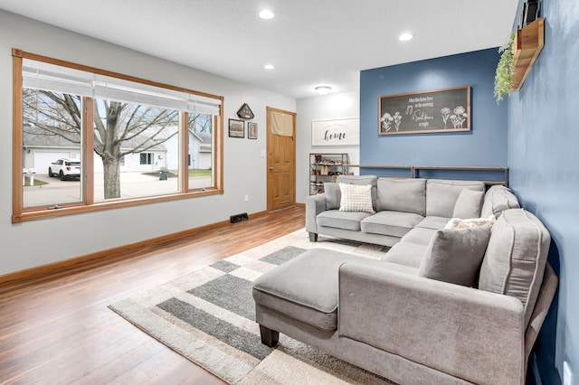 living room with recessed lighting, baseboards, and wood finished floors