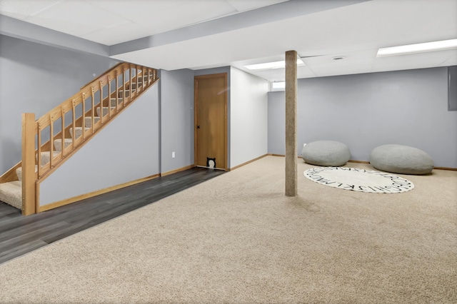 finished below grade area with carpet floors, baseboards, and stairway