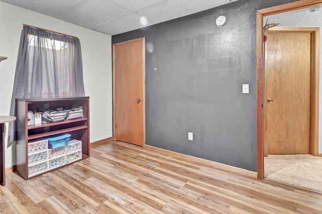 spare room with baseboards and wood finished floors