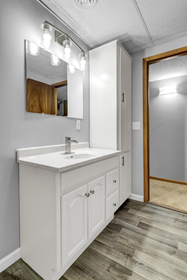 bathroom featuring vanity, baseboards, and wood finished floors