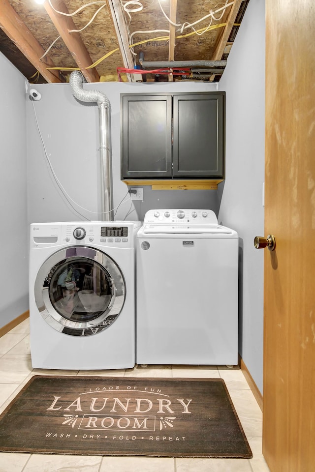 laundry area featuring baseboards, cabinet space, and washer and clothes dryer