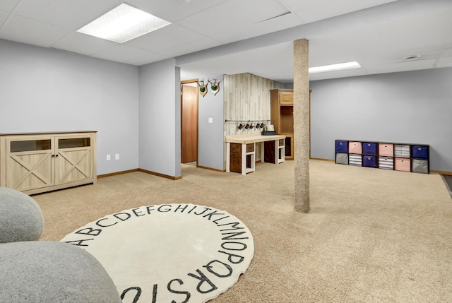 playroom with carpet floors, baseboards, and a paneled ceiling