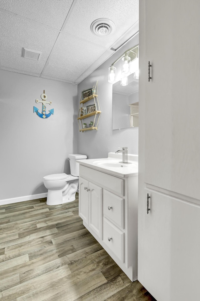 bathroom featuring toilet, visible vents, wood finished floors, and vanity