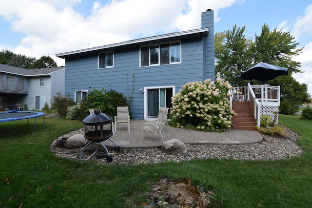 5634 142nd St W, Apple Valley, MN 55124 - back of house with stairs, a chimney, a trampoline, and a lawn