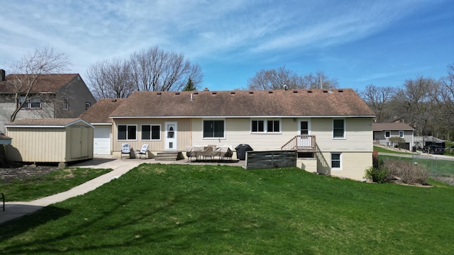 rear view of property featuring a storage unit, a shingled roof, an outbuilding, a patio, and a yard