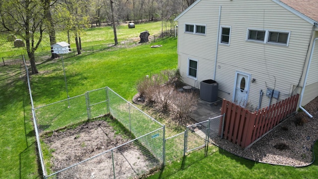 exterior space with a gate, central air condition unit, a yard, and a fenced backyard