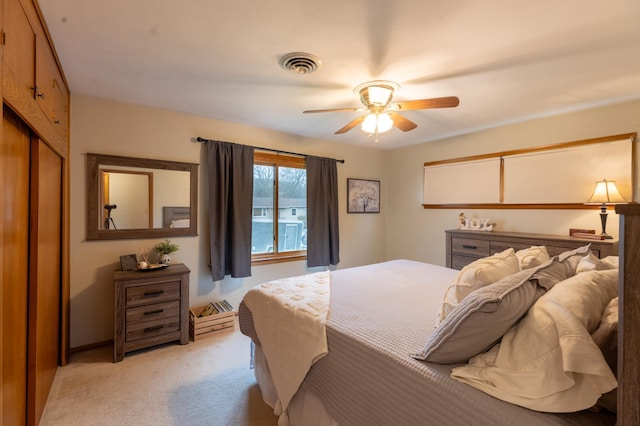 bedroom with light carpet, a ceiling fan, and visible vents