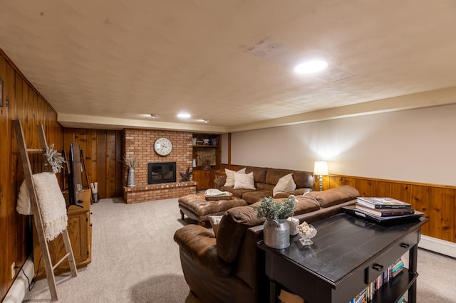 living room with wainscoting, a brick fireplace, light carpet, wooden walls, and a baseboard heating unit