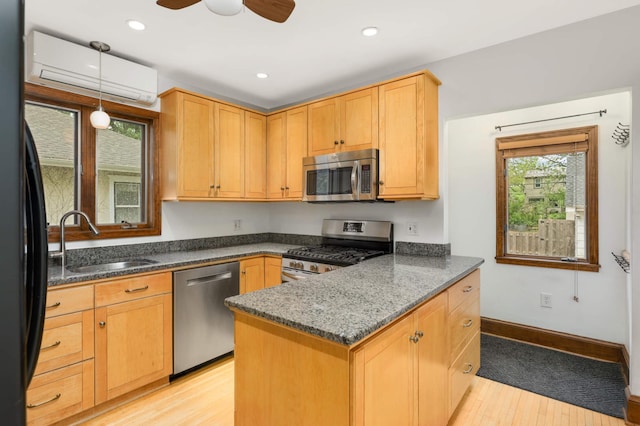 1287 Avon St N, Saint Paul, MN 55117 - kitchen featuring appliances with stainless steel finishes, a sink, a wall mounted air conditioner, light wood-style floors, and decorative light fixtures