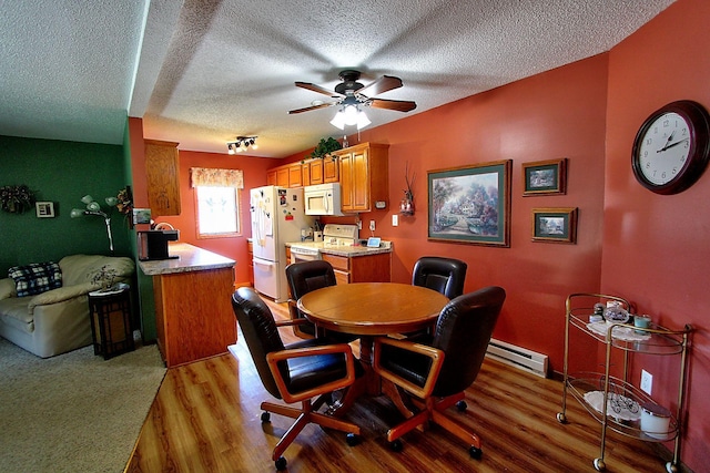 222 Sargent Dr Unit 102, Red Wing, MN 55066 - dining room with light wood-style floors, a baseboard radiator, a ceiling fan, and a textured ceiling