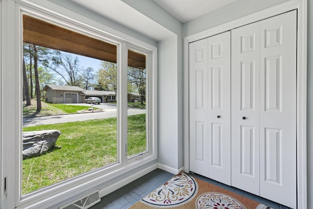 entryway with dark tile patterned floors, visible vents, and baseboards