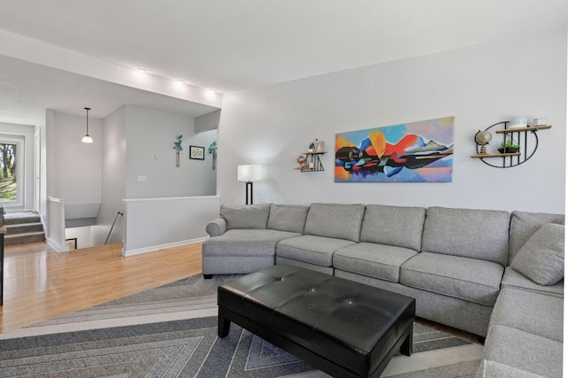 living area with baseboards and wood finished floors