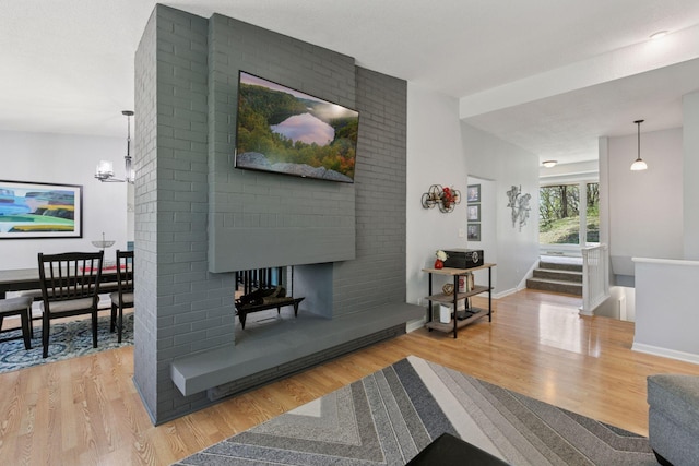 living room with baseboards, stairway, a fireplace, and wood finished floors