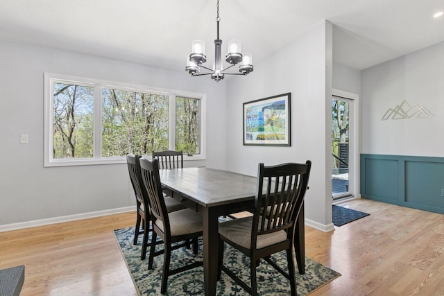 dining space with light wood finished floors and a notable chandelier