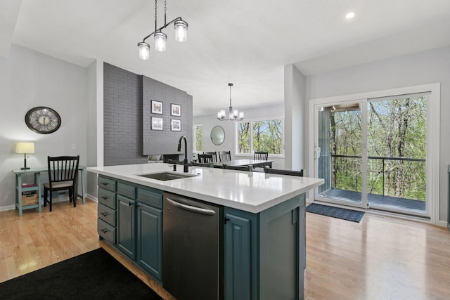 kitchen with light wood finished floors, dishwasher, light countertops, and a sink