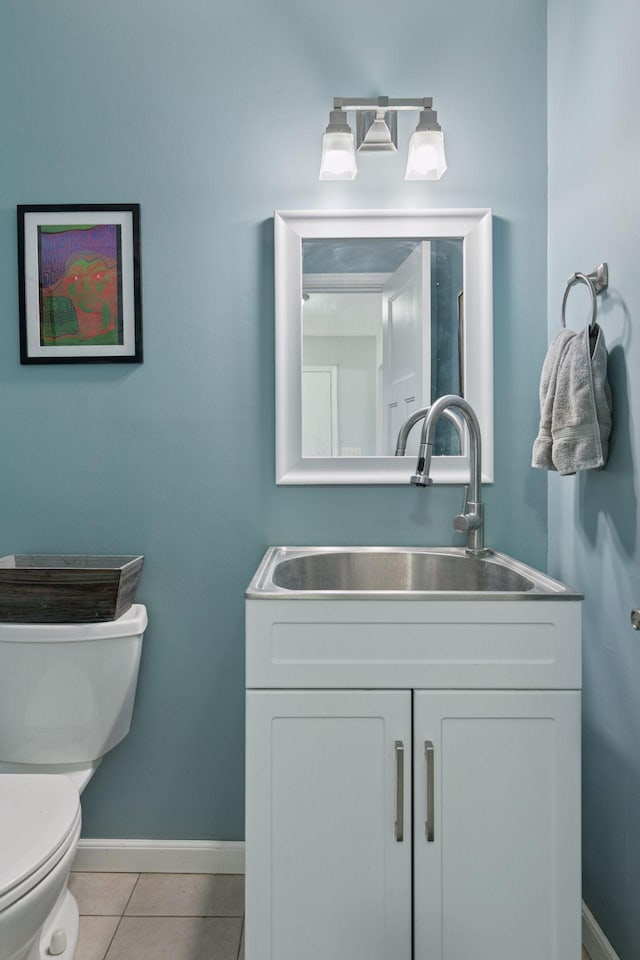 bathroom with baseboards, tile patterned flooring, vanity, and toilet