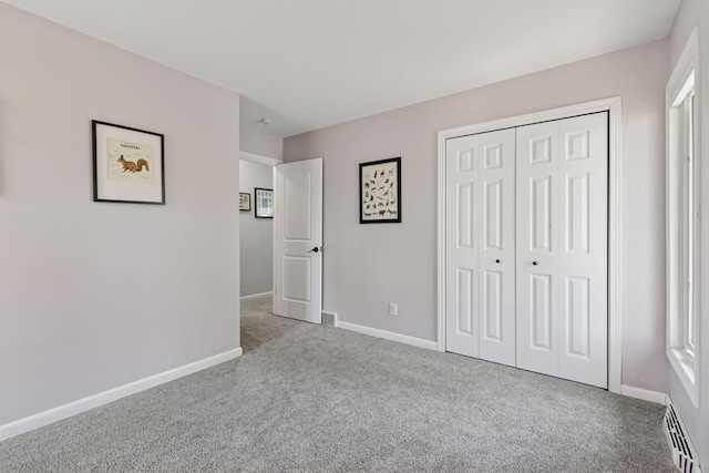 unfurnished bedroom with carpet flooring, baseboards, a closet, and visible vents