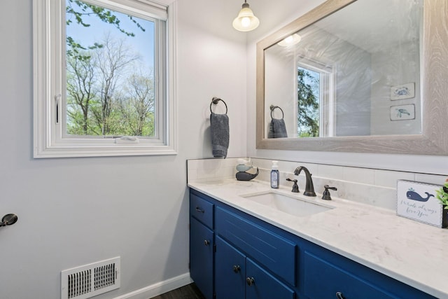 bathroom with baseboards, vanity, and visible vents