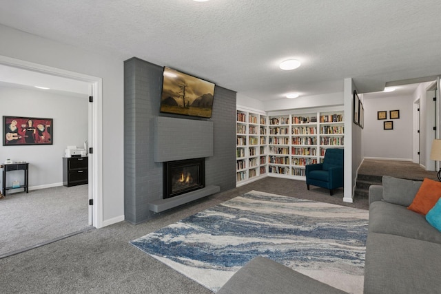 carpeted living area with baseboards, a brick fireplace, and a textured ceiling
