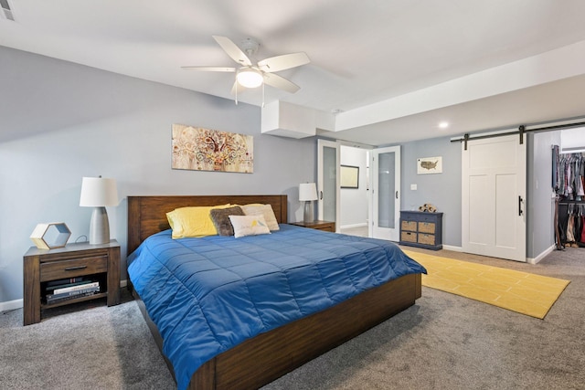 bedroom featuring light colored carpet, a barn door, visible vents, ceiling fan, and baseboards