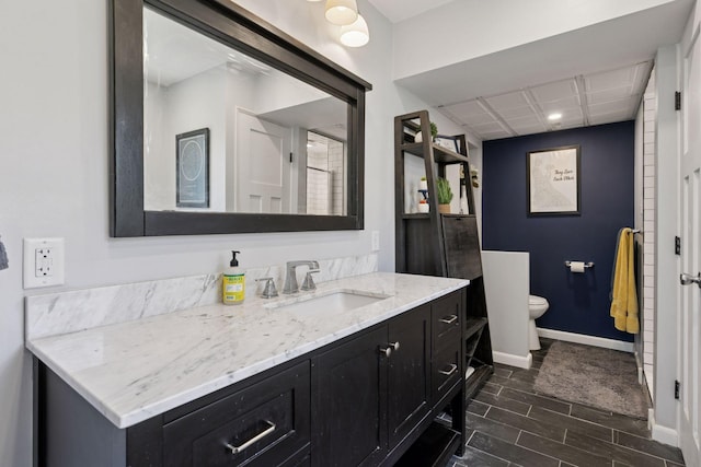 full bathroom with toilet, wood finished floors, baseboards, vanity, and recessed lighting