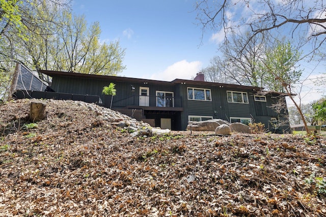 back of property featuring a chimney and a balcony