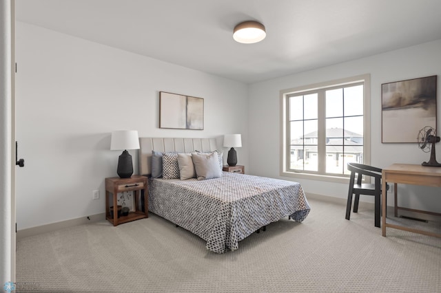 bedroom with baseboards and light colored carpet